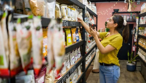 A millennial shopper peruses shelves at the grocery store.