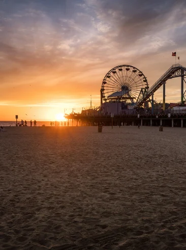 Sunset on a beach near pier.