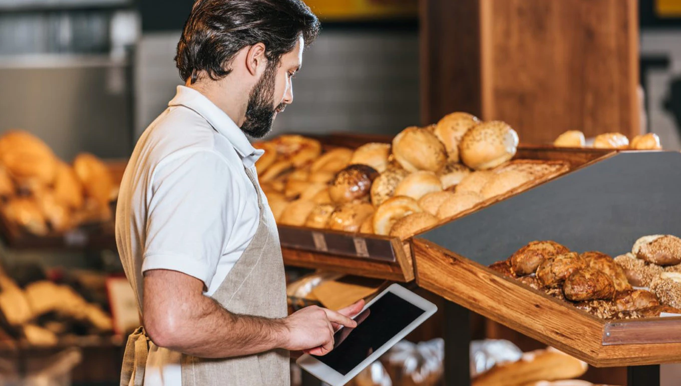 man with tablet next to bread