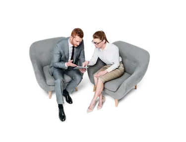 Man and woman talking over tablet from sofa chairs
