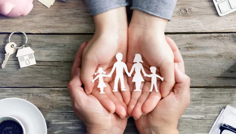 hands holding paper family cutout