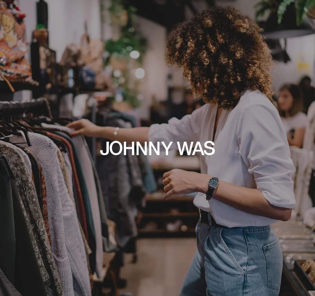 Johnny Was logo with a background featuring a woman looking at clothes.