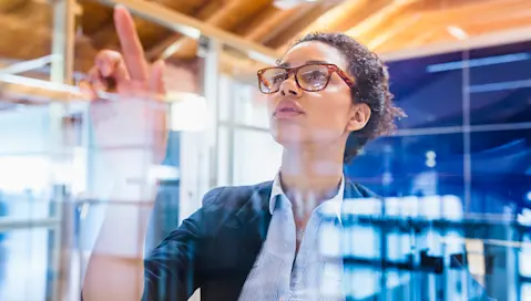 Woman pointing at a board.
