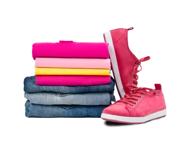 Ein Stapel gefalteter Kleidung und ein Paar rosa Turnschuhe