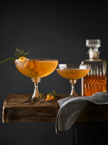 Garnished orange cocktails on a wooden table