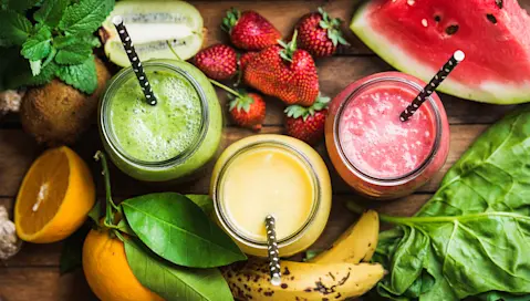 Fresh fruit smoothies from watermelon, kiwi and banana in jars on table