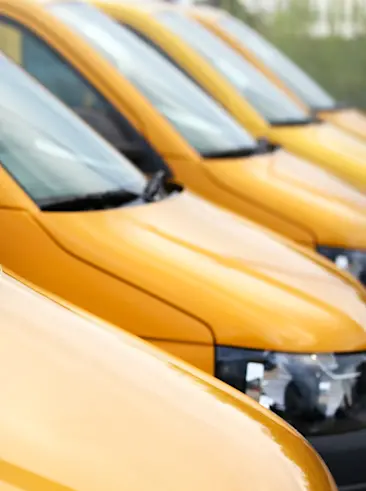 Yellow delivery trucks parked in a line.