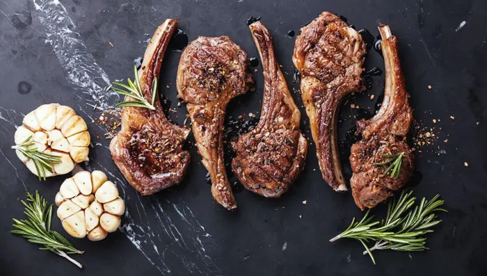 Meat, garlic, and rosemary on a slate