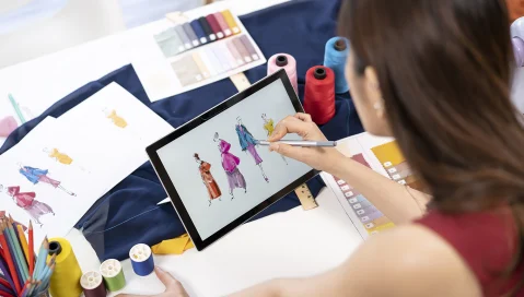 Fashion designer coloring new clothing designs on tablet
