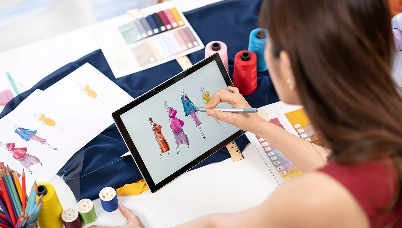 Fashion designer coloring new clothing designs on tablet