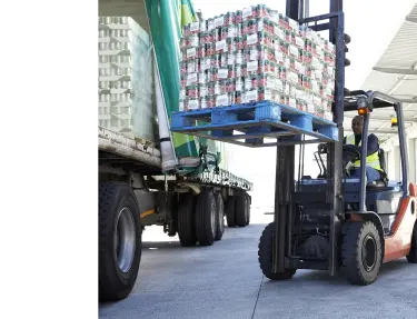 Forklift lifting placing a pallet of inventory into a truck.