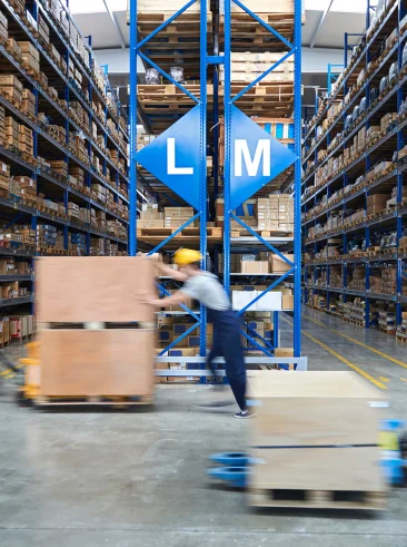 Workers on warehouse floor moving inventory.