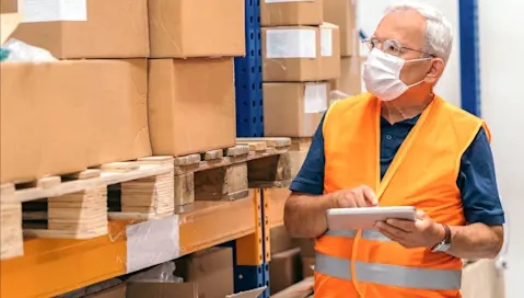 man with tablet next to boxes