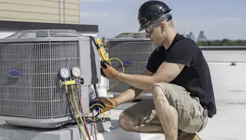 HVAC tech looking at a multimeter