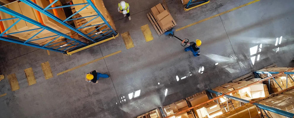 Forklift operator lifting pallets and boxes in a logistics distribution centre
