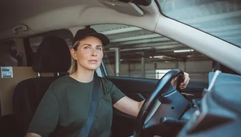 female driver sitting in a car.