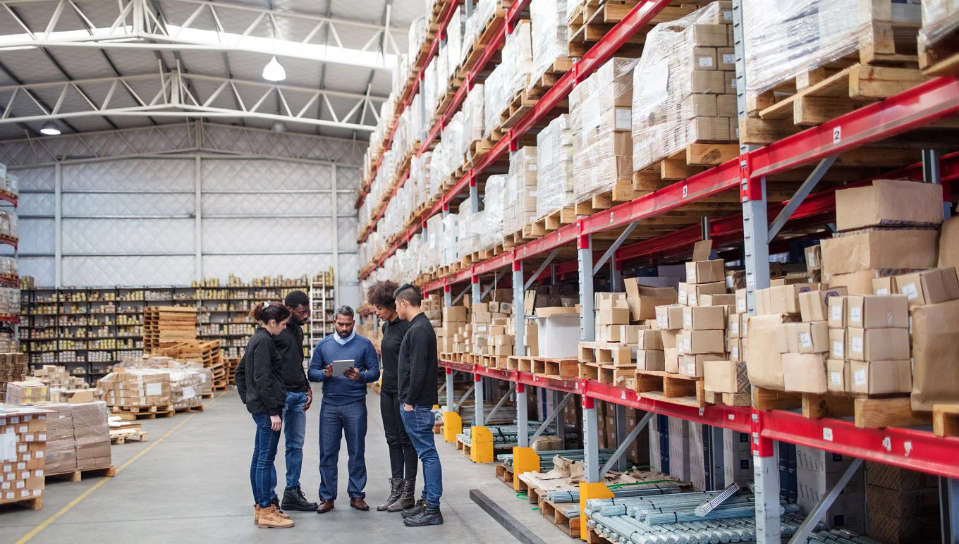 Group of workers standing in warehouse.