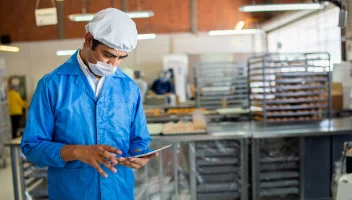Man on tablet on food factory floor