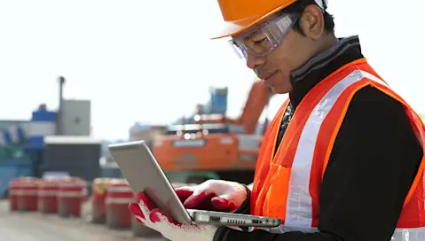 Man in construction clothes on laptop