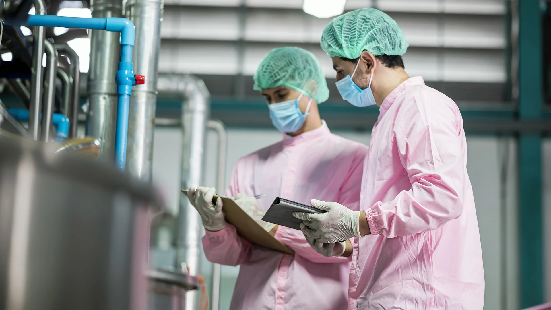 Inspectors looking at clipboard in beverage factory