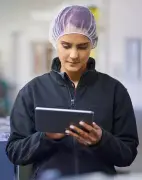 Een werknemer in een magazijn met een tablet