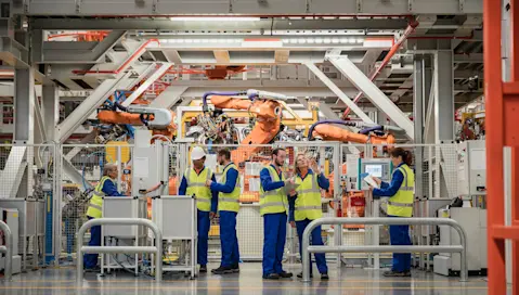 Workers on factory floor near machines and equipment