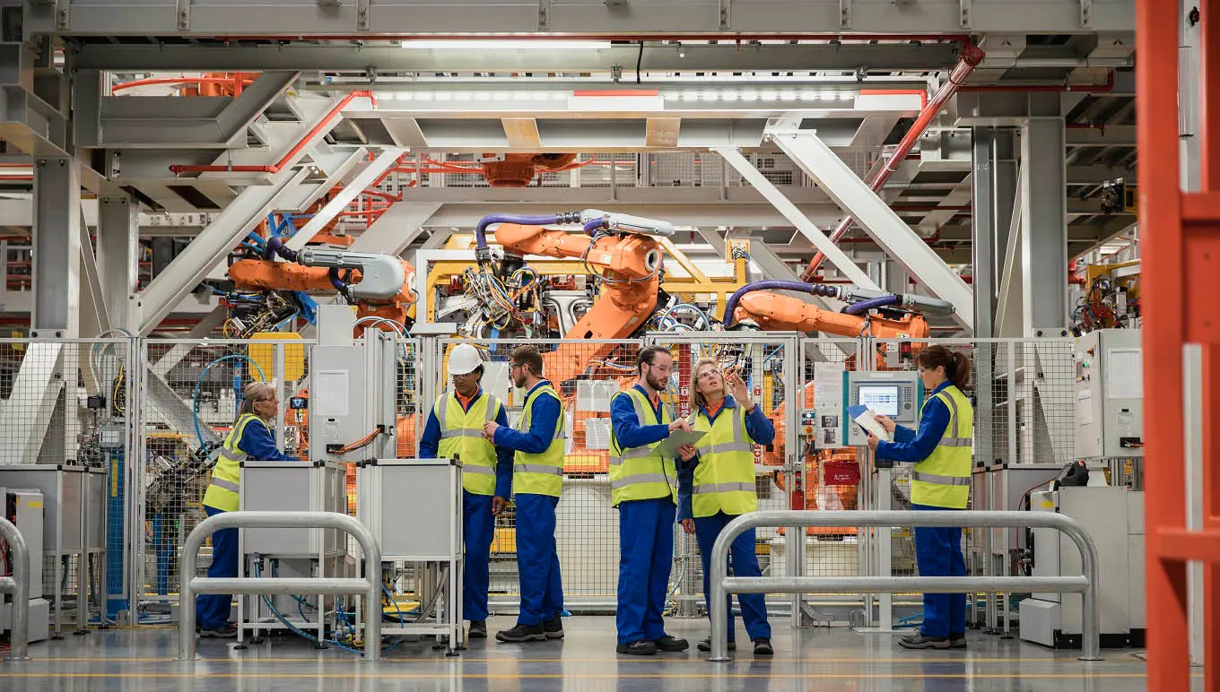 Workers on factory floor near machines and equipment