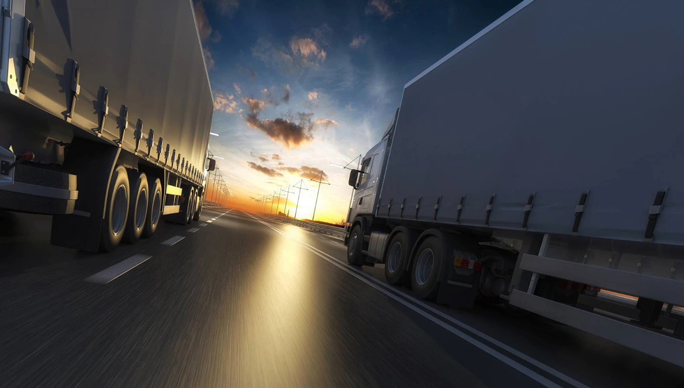 trucks driving at sunset