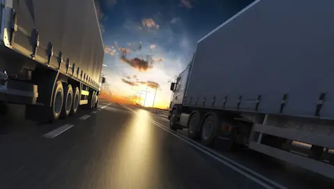 trucks driving at sunset