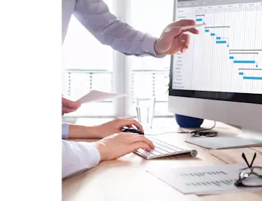 Two people looking at a computer analyzing data.