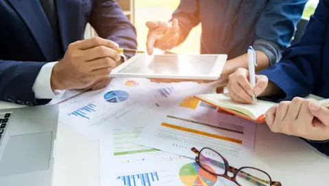 A group of people reviewing data and charts during a meeting.