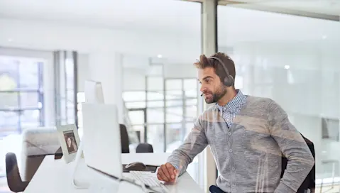 Man sitting in office in front of computer.