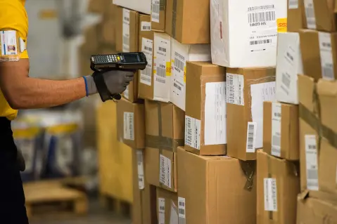 Worker scanning barcodes on boxes