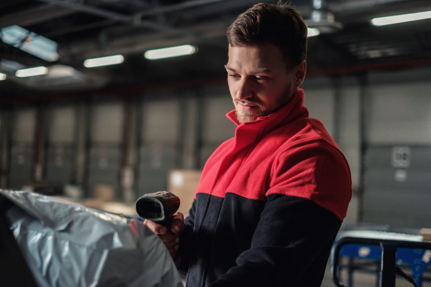Warehouse worker scanning package with barcode scanner