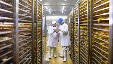 Two food facility workers review documents.