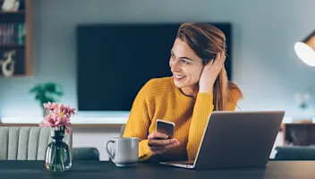 Woman looking to the side while holding her cellphone.