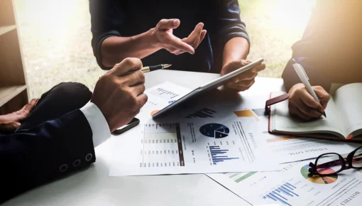 Reviewing tablet and financial data at meeting table