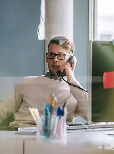 Kantoormedewerker aan de telefoon aan het bureau.