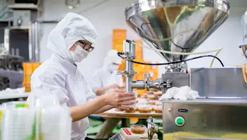 Food factory worker filling containers