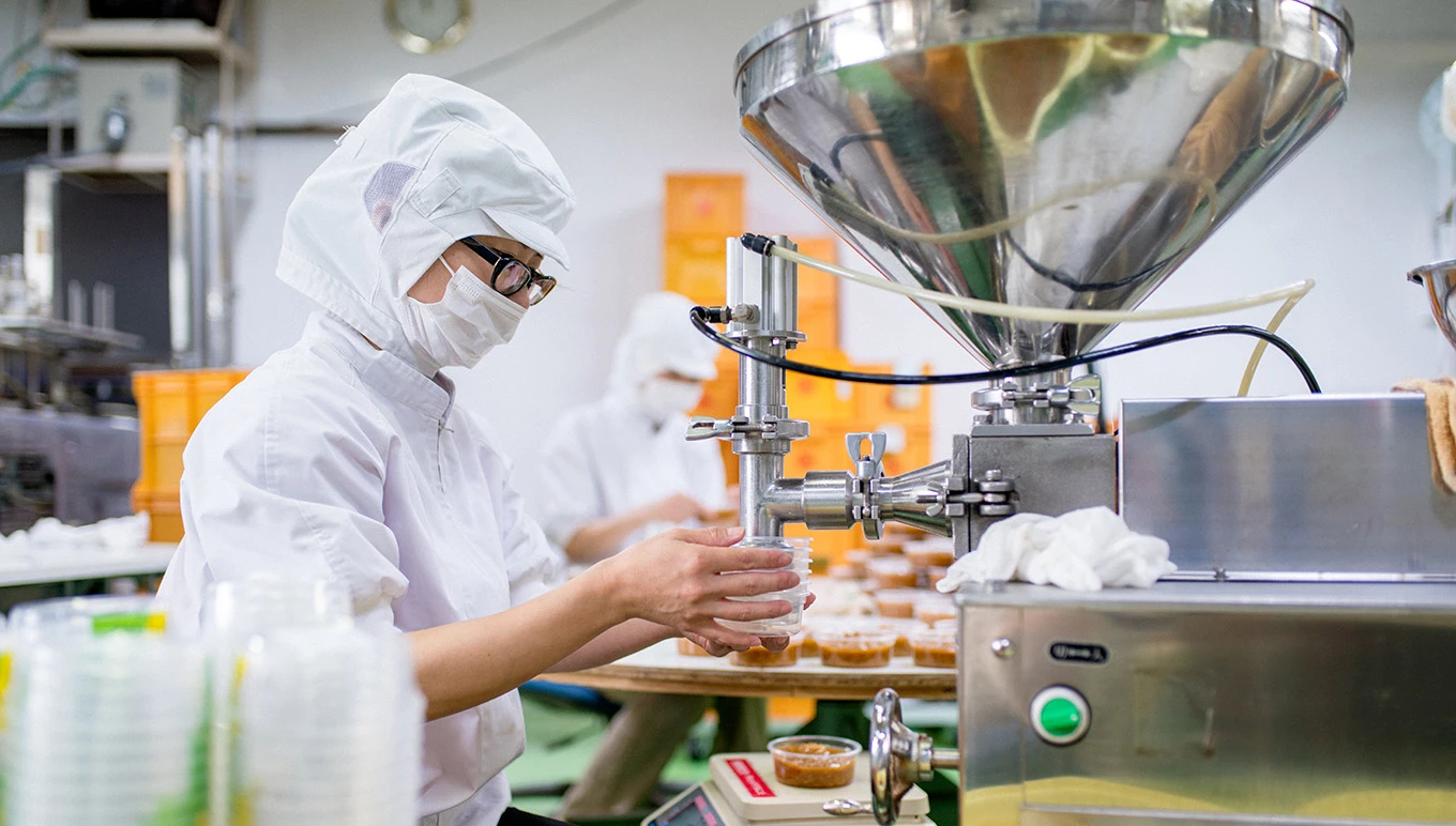 Food factory worker filling containers