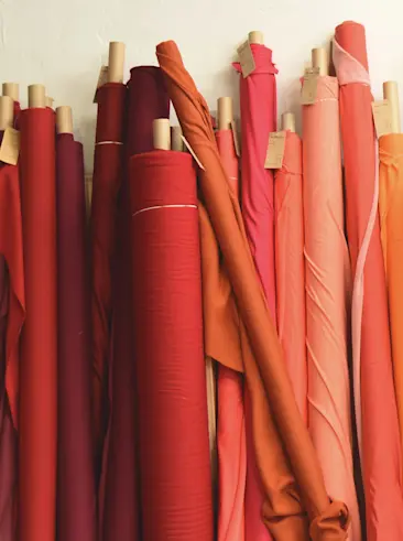 Bolts of colorful fabrics lined up in rolls