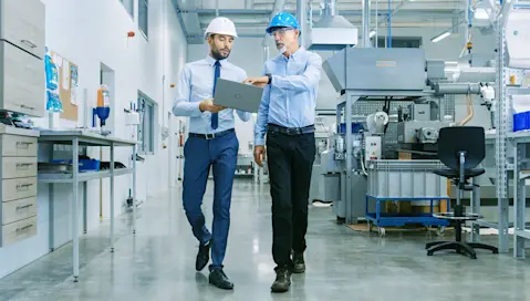 professional men walking discussing on a tablet