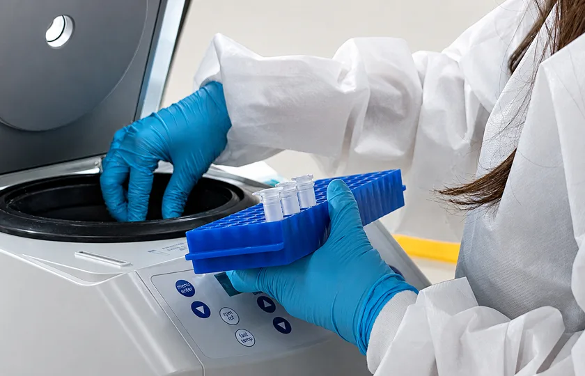 Laboratory technician using a centrifuge for clinical sample testing