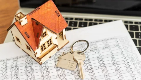 key and miniature house on mortgage spreadsheet