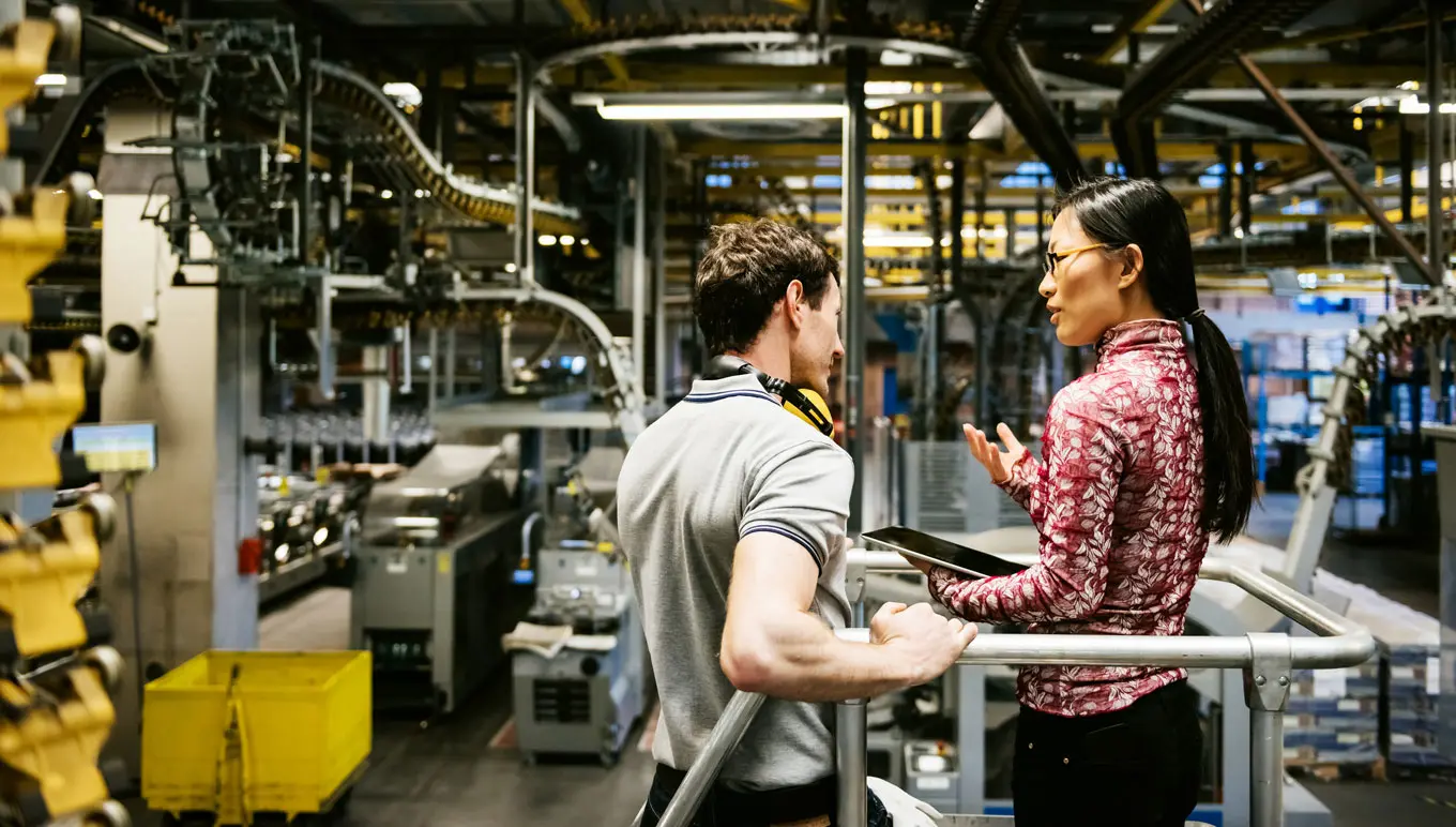 Business professionals talking in an industrial manufacturing warehouse