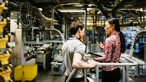 Business professionals talking in an industrial manufacturing warehouse