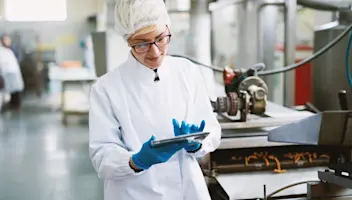 A food facility worker utilizes integrated software solutions via tablet.