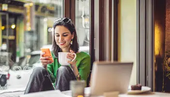 Woman drinking coffee discovering AI in Financial Services