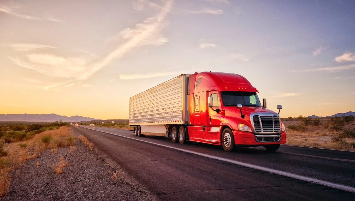 Truck driving on desert road.