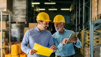 Men in hard hats walking in warehouse